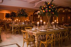 un salón de banquetes con mesas largas con flores y velas en Hotel Tativan en Valledupar