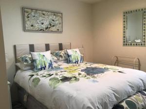 uma cama com um edredão branco com flores em The Gallery em Taupo