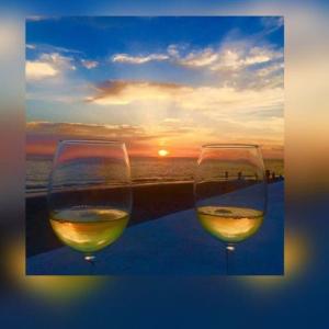 two glasses of wine with the sunset in the background at SUITEBEACH b&b and resort in Marsala