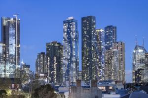 a city skyline with tall buildings at night at Q Squared Serviced Apartments in Melbourne