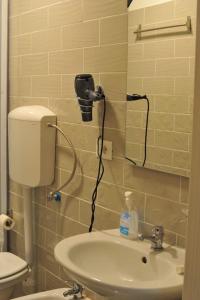 a bathroom with a sink and a hair dryer on the wall at AFFITTACAMERE ROMANSTYLE in Rome