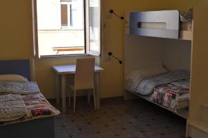 ローマにあるAFFITTACAMERE ROMANSTYLEのベッド2台、テーブル、窓が備わる客室です。