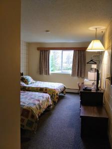 A bed or beds in a room at Haida Way Motor Inn