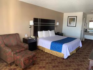 a hotel room with a bed and a chair at Travelodge by Wyndham Killeen/Fort Hood in Killeen +24 photos