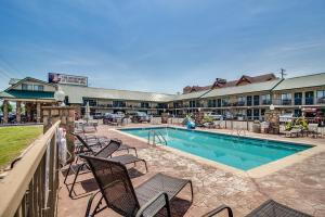 a resort with a pool and chairs and a building at Mountain Breeze Motel in Pigeon Forge