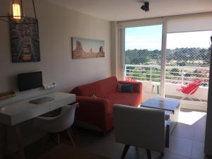 a living room with a red couch and a desk at Green Life - Club Vacacional y SPA in Punta del Este