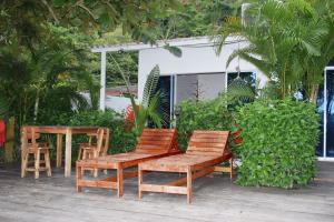 dwa krzesła i ławka na patio w obiekcie Hostal Hilltop Sapzurro w mieście Zapzurro