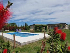 a swimming pool in a yard next to a house at Rincón del Alma in Saladillo