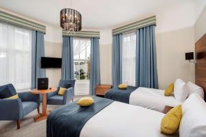 a hotel room with two beds and a table and chairs at New Continental Hotel; Sure Hotel Collection by Best Western in Plymouth
