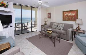 ein Wohnzimmer mit einem Sofa und einem TV in der Unterkunft Sunswept 601 Condo in Orange Beach