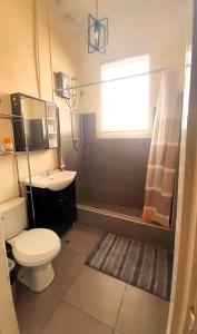 a bathroom with a toilet and a sink and a window at HEART OF PLAZA SAN MARTIN - 2 Boutique Apartments in Lima