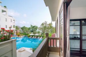 uma vista para a piscina a partir da varanda de um hotel em B'Lan Riverside Villa em Hoi An