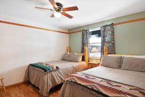 1 dormitorio con 2 camas y ventilador de techo en Foothills Lodge and Cabins, en South Fork