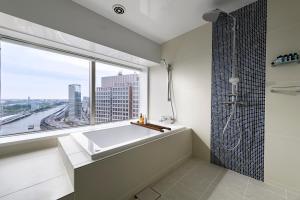 a bathroom with a tub and a window at Dai-ichi Hotel Tokyo Seafort in Tokyo
