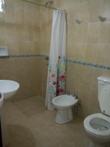 a bathroom with a toilet and a shower curtain at Cabañas Soleado Villa Cura Brochero in Villa Cura Brochero