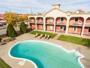 eine Aussicht auf den Pool vor einem Gebäude in der Unterkunft Motel Classique in Joliette