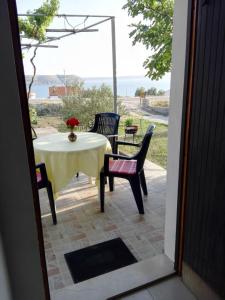 een tafel en stoelen op een patio met uitzicht op de oceaan bij Apartment JoPek - sea view; in Rtina