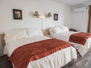 a hotel room with two beds in a room at Motel Classique in Joliette +32 photos