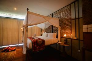 a bedroom with a bed with a canopy at Taman Nauli Boutique Rooms in Canggu