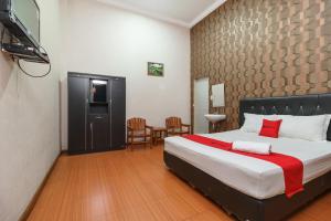 Un dormitorio con una cama y una mesa y sillas. en RedDoorz at Sedayu 2 Near Danau Toba Parapat, en Parapat