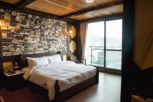 魚池鄉的住宿－湧泉民宿，一间卧室设有一张大床和石墙
