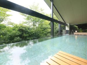 una piscina cubierta con vistas a los árboles en Shimoda Central Hotel, en Shimoda