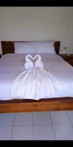 een bed met een witte jurk erop bij Serongga guest house in Lebih
