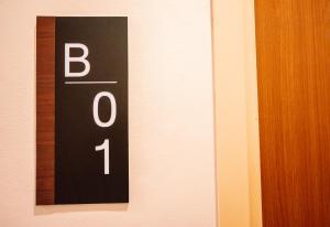 a black and white sign on a wall at Tripletreesvillage in Ban Sai Mai