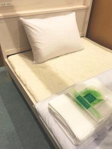 1 cama con almohada y toallas en ROSE ROOM en Fukuyama