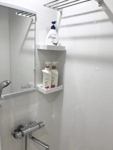 Un baño con un estante con botellas de leche. en ROSE ROOM en Fukuyama