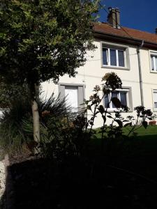 ein weißes Haus mit einem Baum davor in der Unterkunft Jolie maison de campagne in Fresnes-en-Woëvre