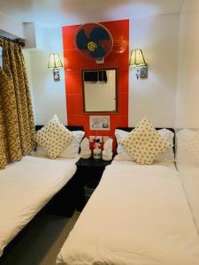two beds in a room with a red wall at Woodstock Hostel in Hong Kong