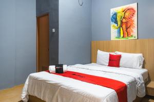 a bedroom with a large bed with red pillows at RedDoorz Plus @ Otista Raya Ciputat in Tangerang