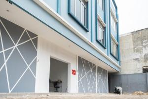 a building with a blue and white facade at RedDoorz Plus @ Otista Raya Ciputat in Tangerang