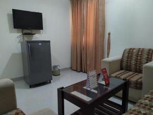 a living room with a tv and a coffee table at Super OYO 107 Al Areen Hotel Apartments in Shāhiq