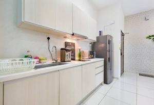a kitchen with white cabinets and a stainless steel refrigerator at COZY D'Summit 2 Bedrooms @ 100mbps HIGH SPEED WIFI in Skudai