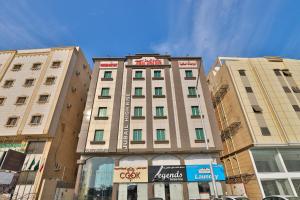 a tall building in the middle of two buildings at Jubail High Rise Hotel in Al Jubail