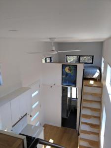 a tiny house with a bed and a staircase at Bottletree Gardens - Mini Manson Blue in Gold Coast