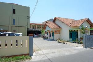 eine Straße mit zwei Häusern und einem Zaun in der Unterkunft RedDoorz Syariah near Alun Alun Pati in Pati