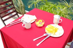 een rode tafel met een bord eten erop bij OYO 473 Suburban Villa in Hội An