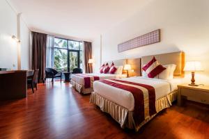 Una habitación de hotel con dos camas y un escritorio. en Tunamaya Beach & Spa Resort- Desaru, en Desaru 69 fotos más