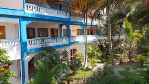 an exterior view of a building with palm trees at Victory Hotel & Restaurant Tulear in Toliara