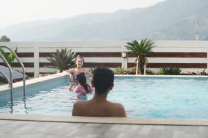 a woman and a child in a swimming pool at Nirvana Villas Puncak in Puncak
