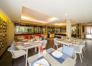 a restaurant with tables and chairs and a bar at The Rock Hua Hin Beachfront Spa Resort - SHA Plus in Hua Hin