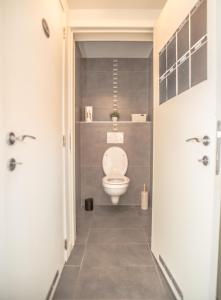 a bathroom with a white toilet in a room at De Lievensmolen in Damme