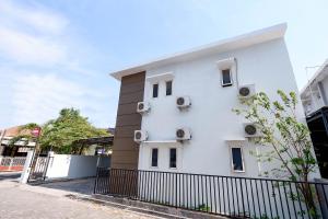 a white building with a fence in front of it at Super OYO 1565 Palebon Residence in Semarang