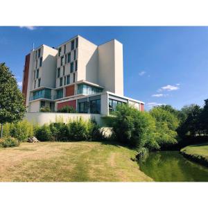 ein Gebäude mit einem Fluss davor in der Unterkunft Hotel du Pasino in Saint-Amand-les-Eaux