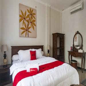 a bedroom with a large bed with red pillows at RedDoorz Syariah Plus near Trans Studio Cibubur in Cibubur