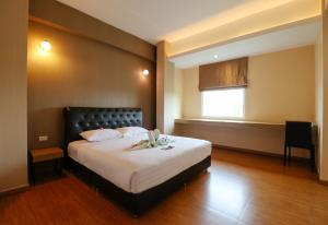 a bedroom with a bed with two towels on it at Tripletreesvillage in Ban Sai Mai +42 photos