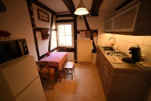 a kitchen with a stove and a table in it at Gite Bim Maidala in Colmar